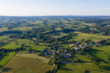 Drone aerial image of agricultural landscape near Waimes in the Belgian Ardennes, June 2020. Rich green fields, scattered farms and winding roads create a quilt-like pattern across the summer countrys