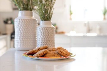 Homemade gingersnap cookies on the counter in a clean white kitchen - 393221010