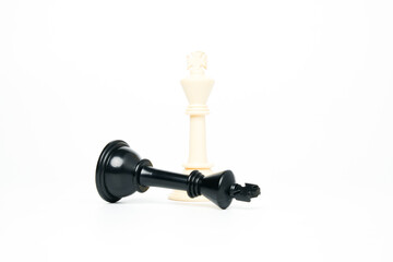 Selective focus of black chess king with topple white chess king on isolated white background for...