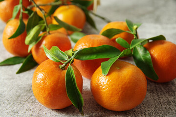 Big bunch of ripe juicy tangerines with green leaves. Fresh fragrant mandarins. 