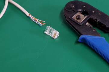 cat5 network cable with exposed wires and rj45 plug with crimping tool