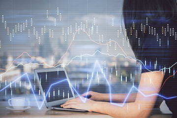 Double exposure of businesswoman hands typing on computer and forex chart hologram drawing. Financial analysis concept.