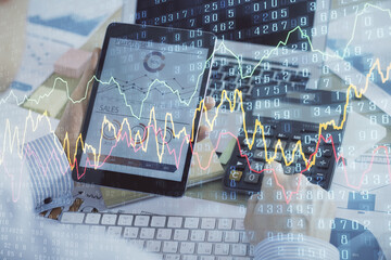 Double exposure of man's hands holding and using a digital device and forex graph drawing. Financial market concept.