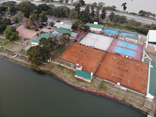 Canchas de tenis ingles de polvo de ladrillo un dia de lluvia en un club náutico de la ciudad de...