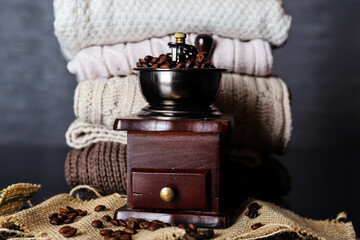 Roasted coffee beans in a wooden retro mill on a desk at home. Copy space for design or text