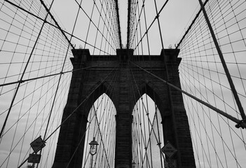 Grayscale low angle shot of the Brooklyn Bridge in USA