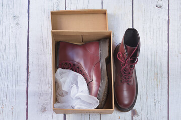Garnet maroon military boots inside a cardboard box