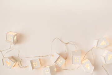 Christmas, winter, new year composition. Christmas garlands in the shape of a house on beige background. Flat lay, top view, copy space