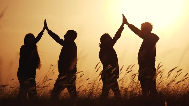teamwork. team of tourists greet each other rejoice in success silhouette. business teamwork a travel tourism concept. group of people clap each other symbol success team of victory