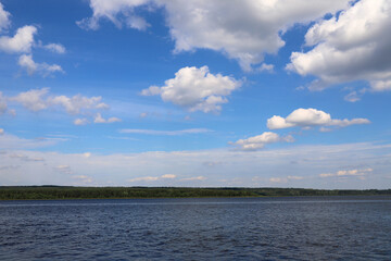 summer landscape with river or lake, forest and blue cloudy sky