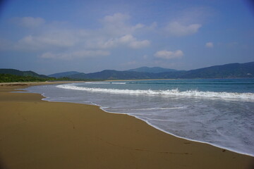 日本の宮崎の波打ち際と山と青空