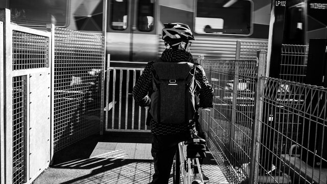 black and white image of a person waiting for the train