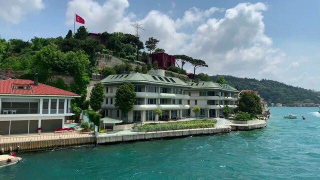 Footage of luxury houses in upscale neighborhood called "Kandilli" by Bosphorus in Istanbul. It is a beautiful summer scene on cloudy summer day. Camera moves forward.