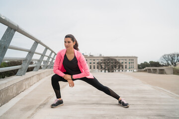 Fototapeta na wymiar Athletic woman stretching legs before exercise.