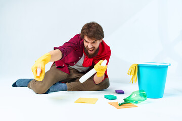 A man in a red raincoat sitting at home washing the floors providing services detergent accessories