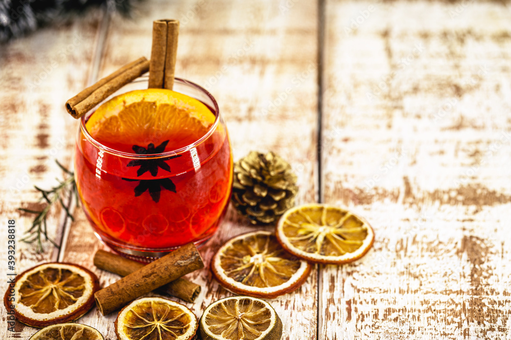 Wall mural Hot Christmas punch with citrus fruits on a winter table, front view, festive warming alcohol concept