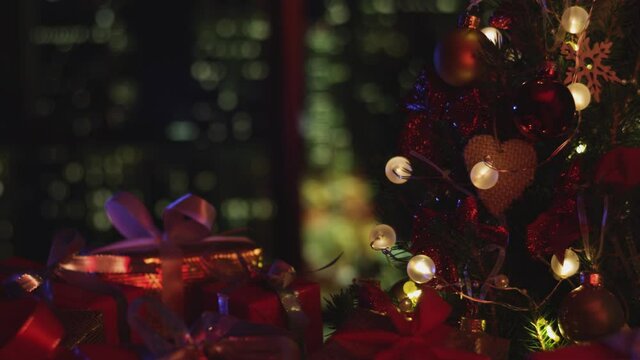 New Years Christmas background. Christmas tree. Flashing lights. Decorations, red gold balls and glowing bulbs on the tree. Warm home mood. Depth of field, soft focus. Red camera 4K