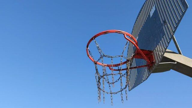 Still shot from below basketball hoop on blue sky