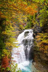 Obraz na płótnie Canvas Upright photography of Cascada Del Estrecho ( Estrecho waterfall) during Autumn season,, in Ordesa valley Heusca, Spain