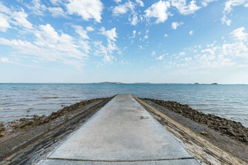 Fototapeta na wymiar The reef dam protruding into the sea, against blue sky background, Xiamen