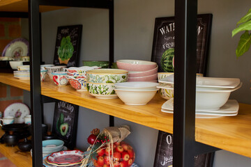 shelf and stand of plates, glasses and ceramic tableware decorated organized and stacked painted green and nature with interior design for the house