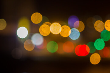 An beautiful Christmas background dark made of blurred colorful lights. Copy space