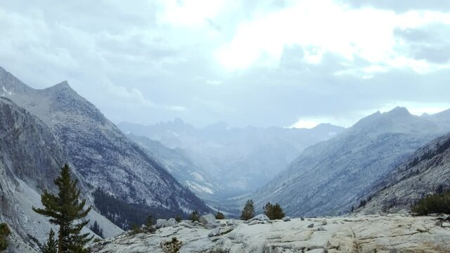 Stunning pan of mountain range canyon along the Sierra Nevadas with cloudy skies (60 fps slowed to 30 fps)