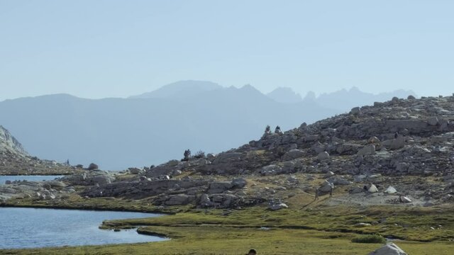 Smooth shot of blue alpine lake overlooking the Sierra Nevadas along the JMT (60 fps slowed to 30 fps)