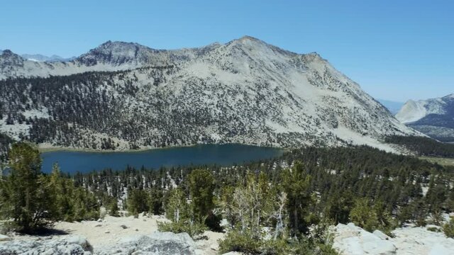 Smooth pan over to view of beautiful blue lake in the Sierra mountains on a clear sunny day (60 fps slowed to 30 fps)