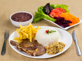 Typical Brazilian food, executive dish, food menu. Rib, rice, beans, potato and crumbs with accompaniments