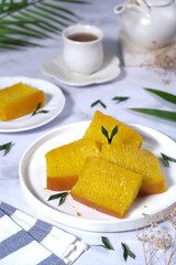 Bika Ambon, Indonesian honeycomb cake with square slices in white plate.
It is made of flour, tapioca, coconut cream, lime leaf, and sugar. Selective focus.
