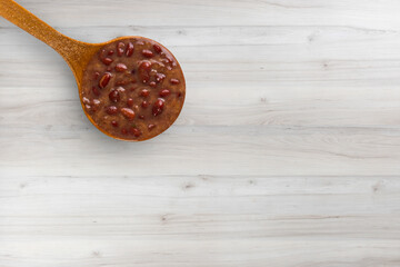 A spoon with Brazilian Feijoada Food. Top view. wooden table background. Copy sapce