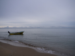 Obraz premium A small fishing boat on the beach at hua hin province