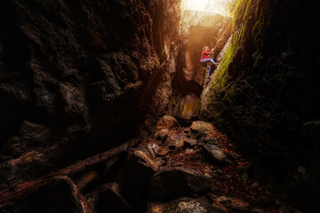 Adventurous girl is climbing down into a rocky cave. Taken in Skaha Bluffs Provincial Park,...