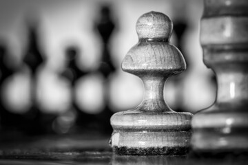 Wooden chess pieces stand on the board in the starting position before the battle.