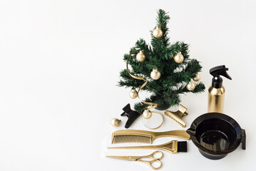 Banner with hairdressing tools in gold color and a Christmas tree on a white background. Holiday template with hair salon accessories with space for text.