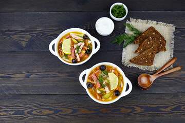 The traditional Russian dish  is saltwort  (Solyanka)- a thick, spicy and sour-salty soup. Served with sour cream. Top view, copy space.