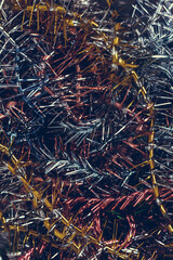 A lot of Christmas colorful vintage tinsel. Color festive Christmas vertical toned background