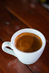 white cup of brown coffee in a table