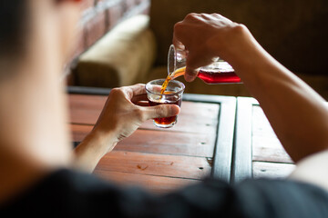 closeup male pour coffee into a cup in a cafe