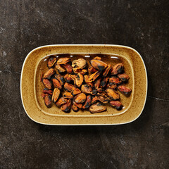 Mussels cooked without shells in tomato sauce on black marble table