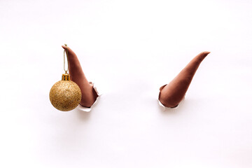 Two brown bull horns break through the white background.On one horn is a golden ball.Bull as a...