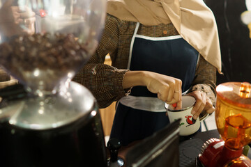 female batender showing process make a coffee in cafe