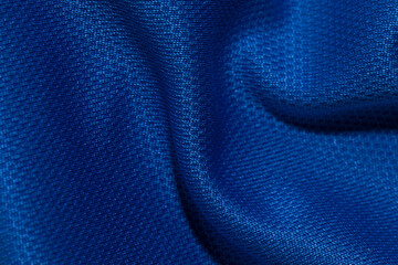 waves on surface of fabric of deep classic blue color. crumpled texture of smooth material of dense weaving as pattern background