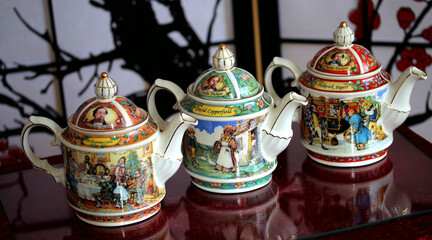 Closeup of colorful vintage ceramic teapots on the table with a blurry background