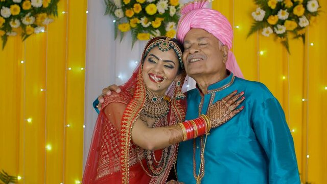 Attractive bride happily standing on the stage with her father - Indian wedding. Father-daughter bonding - Happy north Indian bride on her marriage - Decorated stage /matrimonial day
