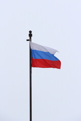 Russian flag on a light sky background, white, blue and red tricolor