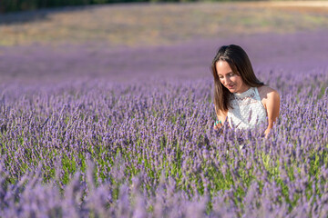 jeune fille en robe blanche au milieu d'un  champ de lavande