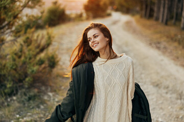 Smiling woman in white sweater jacket on nature walk leisure