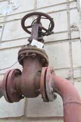Old damaged and rusty iron oil pipe valve wheel. Metal, pipeline and mechanic concept. An old iron...